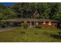 Charming brick ranch-style home with covered carport and a well-manicured front lawn at 3055 Henderson Mill Rd, Atlanta, GA 30341
