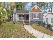 Charming home featuring grey siding, purple shutters, and a well-manicured front yard at 1686 Alvarado Sw Ter, Atlanta, GA 30310