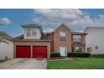 Charming two-story brick home featuring a two-car garage and well-manicured lawn at 1801 Deer Crossing Cir, Jonesboro, GA 30236