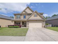 Charming two-story home with manicured lawn, inviting entryway, and neutral exterior paint at 4251 Haywater Cv, Buford, GA 30519