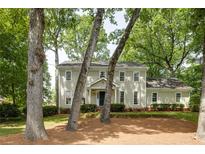 Charming two-story traditional home with a manicured lawn and mature trees providing shade at 1404 Vernon North Dr, Dunwoody, GA 30338