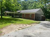 Charming one-story brick home with a spacious front yard and ample parking on a paved driveway at 2934 Union Grove Rd, Conyers, GA 30012
