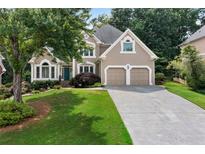Charming traditional home with lush front yard, manicured landscaping, and two-car garage at 1377 Downington Nw Ln, Acworth, GA 30101