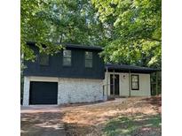 Charming two-story home featuring a dark upper level, stone accents, and an attached garage at 5401 Martins Crossing Rd, Stone Mountain, GA 30088