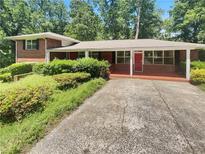 Charming single-story home featuring a brick facade, covered porch, and well-maintained landscaping at 710 Montclair Sw Dr, Smyrna, GA 30082