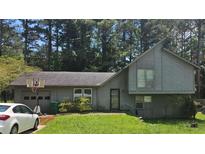 Charming two-story home with a basketball hoop on the garage, neutral siding, and mature trees at 4287 Ridgetop Trl, Ellenwood, GA 30294