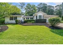 Charming home featuring a lush green lawn, mature landscaping, and a welcoming facade at 4458 Trickum Ne Rd, Marietta, GA 30066