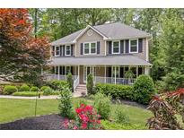 Charming two-story home with a welcoming front porch and beautifully landscaped front yard at 5107 Old Chestnut Ct, Woodstock, GA 30188