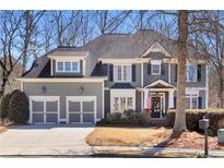 Charming two-story home with a manicured lawn, two-car garage and an American flag at 1604 Summersweet Ln, Dacula, GA 30019