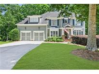 Charming two-story home featuring a manicured lawn, attached garage, and traditional architectural details at 1604 Summersweet Ln, Dacula, GA 30019