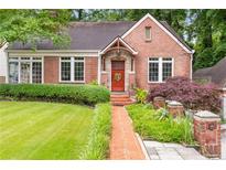Charming brick home featuring a well-manicured lawn and a brick walkway leading to the front door at 228 Clarion Ave, Decatur, GA 30030