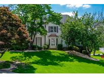 Charming two-story home featuring a lush green lawn and mature trees at 1130 S Rudder Rd, Cumming, GA 30041