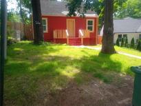 Charming red home with a cozy front porch and lush green lawn at 1105 Oak Knoll Ter, Atlanta, GA 30315