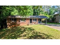 Cozy one-story brick home with a covered carport and a well-maintained front lawn at 2569 Dobbs Nw Dr, Kennesaw, GA 30152