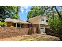 Charming two-story home with brick accents, attached garage and mature trees in a private, wooded setting at 3656 Salem Trl, Lithonia, GA 30038
