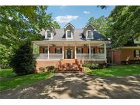 Charming brick home with a welcoming front porch and beautifully landscaped front yard at 4200 E Highway 166 Rd, Carrollton, GA 30116