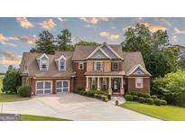 Charming two-story home with manicured lawn, mature trees, and attached two-car garage at 9742 Fallview Ct, Villa Rica, GA 30180