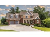 Charming two-story brick home featuring a well-manicured lawn, a driveway to a two-car garage, and decorative landscaping at 9742 Fallview Ct, Villa Rica, GA 30180