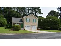 Charming home features a two-car garage and a well-manicured front yard at 5517 Rock Shoals Way, Atlanta, GA 30349