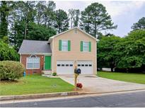 Charming two-story home with a well-manicured lawn, a two-car garage, and a welcoming green front door at 5517 Rock Shoals Way, Atlanta, GA 30349