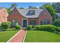 Charming brick home with manicured lawn, lush greenery, and inviting entryway; a beautiful suburban residence at 1146 Cumberland Ne Rd, Atlanta, GA 30306