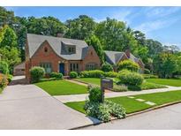 Charming brick home featuring lush lawn, manicured landscaping, and a quaint mailbox at 1146 Cumberland Ne Rd, Atlanta, GA 30306