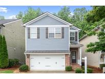 Charming two-story home featuring a brick-accented garage and a well-manicured front yard at 212 Ranier Court, Canton, GA 30114