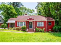 Charming red brick home with a well-manicured lawn and lush green trees at 3020 Washington Rd, East Point, GA 30344