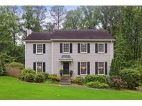 Charming two-story home with a manicured lawn, complemented by lush greenery and a welcoming facade at 3262 Mitsy Forest Way, Marietta, GA 30068