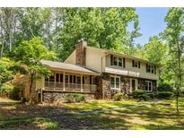 Charming two-story home with stone accents, a cozy front porch, and mature trees on a lush green lawn at 5410 Rosser Rd, Stone Mountain, GA 30087