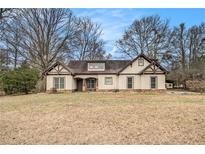 Charming one-story home featuring Tudor-style accents, a dormer, and a well-maintained front yard at 108 Deer Creek Run, Moreland, GA 30259