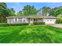 Charming single-story home with a well-manicured lawn and mature trees at 57 Fair Oaks Se Dr, Conyers, GA 30094