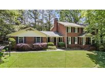Charming brick home featuring a well-manicured lawn and mature landscaping at 4243 Mcclatchey Ne Cir, Atlanta, GA 30342