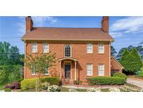 Charming brick two-story home featuring a landscaped front yard and a classic, symmetrical design at 110 Amsterdam Dr, Lilburn, GA 30047