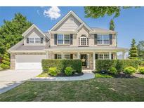 Charming brick home featuring a manicured front yard, covered porch, and attached two-car garage at 2304 Mitford Ct, Dacula, GA 30019
