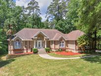 Charming single Gathering home featuring a lush front lawn, beautiful garden beds, and a cozy walkway to the front door at 8443 Marina Bay Ct, Jonesboro, GA 30236