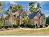 Charming two-story home featuring stone accents, lush landscaping, and a welcoming entrance at 237 Libby Ln, Canton, GA 30115