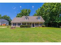 Charming single-Gathering home featuring a welcoming front porch and a lush green lawn at 1406 Windy Ridge Se Ct, Conyers, GA 30013