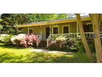 Charming home featuring a quaint front porch and a garden filled with blooming azaleas, showcasing natural beauty at 61 Maxie Ln, Dallas, GA 30157