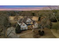 Stunning traditional home featuring mature trees, a circular drive and golf course views at 160 Isleworth Way, Fayetteville, GA 30215