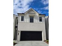 Two-story home with painted brick, vertical siding, and a two-car garage door at 1888 Copelyn Reese Court (Lot 164), Lawrenceville, GA 30043
