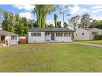 Charming one-story home with white painted brick, wood shutters, and a spacious front lawn at 2677 Tilson Rd, Decatur, GA 30032