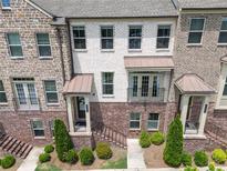 Beautiful brick townhome featuring a covered entry, balcony, and manicured landscaping at 416 Montclair Ct, Woodstock, GA 30188
