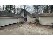 Single-story home with a garage, large front windows, and a classic suburban aesthetic at 95 Lake Top Ct, Roswell, GA 30076