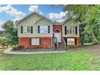 Charming two-story home with brick and siding, complemented by a well-manicured lawn and mature trees at 1400 Scenic Brook Sw Trl, Conyers, GA 30094
