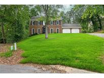 Traditional two-story brick home with a well-manicured lawn and two-car garage at 1911 Woodmont Ct, Marietta, GA 30062