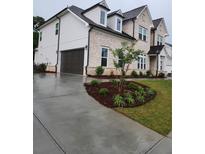 New two-story home with a light brick facade, dark roof, well-manicured lawn and a two-car garage at 2949 Longbush, Duluth, GA 30097