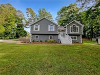 Charming gray home with white trim, well-manicured lawn, and inviting entrance at 5080 Brownwood Dr, Powder Springs, GA 30127