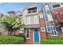 Charming two-story home with a balcony, brick accents, manicured landscaping, and a bright blue front door at 1802 Dekalb Ne Ave, Atlanta, GA 30307