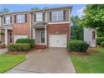 Charming brick townhome with a one-car garage and well-manicured landscaping at 2735 Maple Park Pl # 32, Cumming, GA 30041